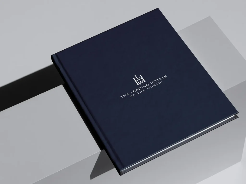 Luxury hardcover corporate portfolio featuring metallic silver foil stamping on navy paper, crafted in our studio for high-end professional organizations.