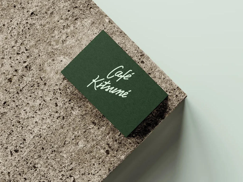 Forest green cafe business card on 32pt matte stock, locally printed in NYC and photographed on a grey granite slab.