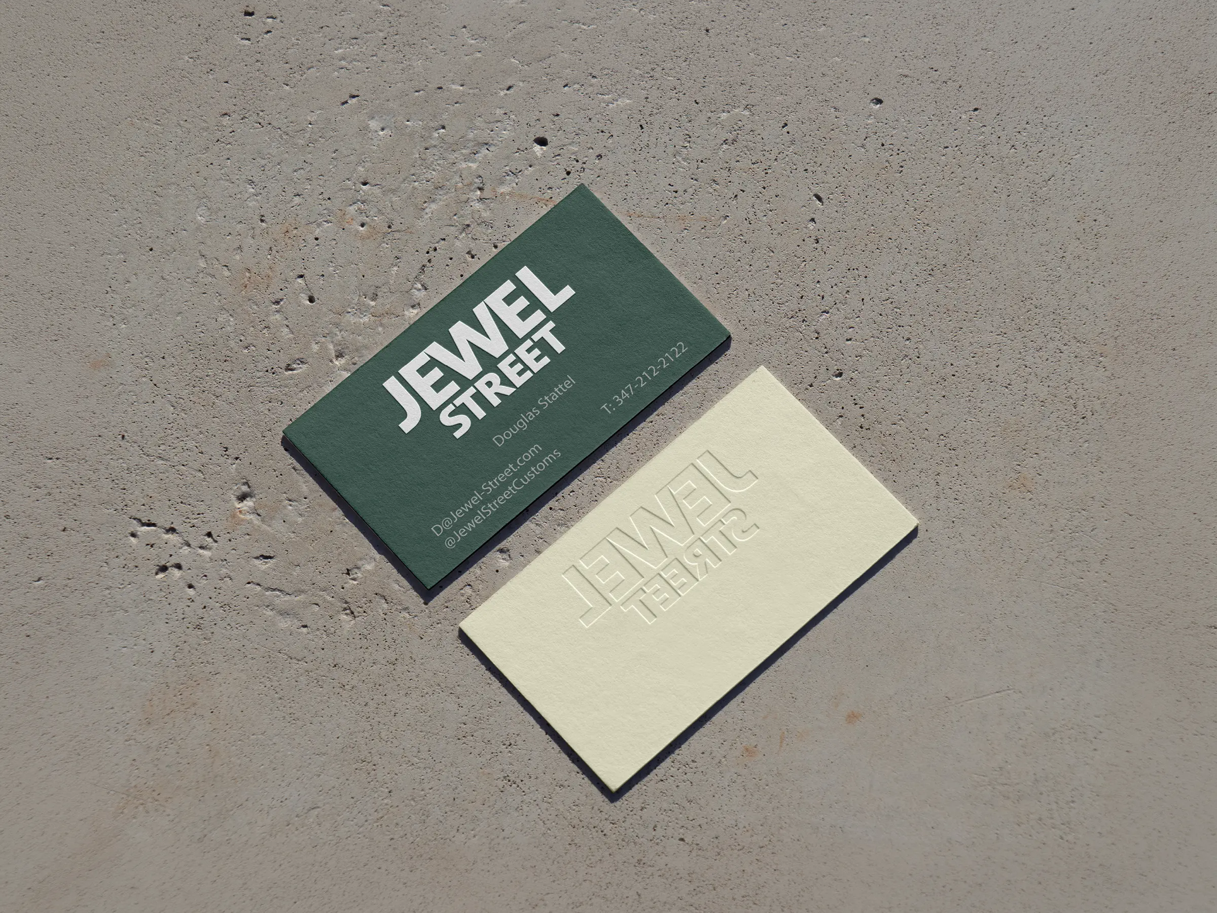 Premium embossed business cards for Jewel Street featuring deep 3D texture on forest green and cream cardstock, custom-printed at our NYC shop for a dimensional, high-end feel.