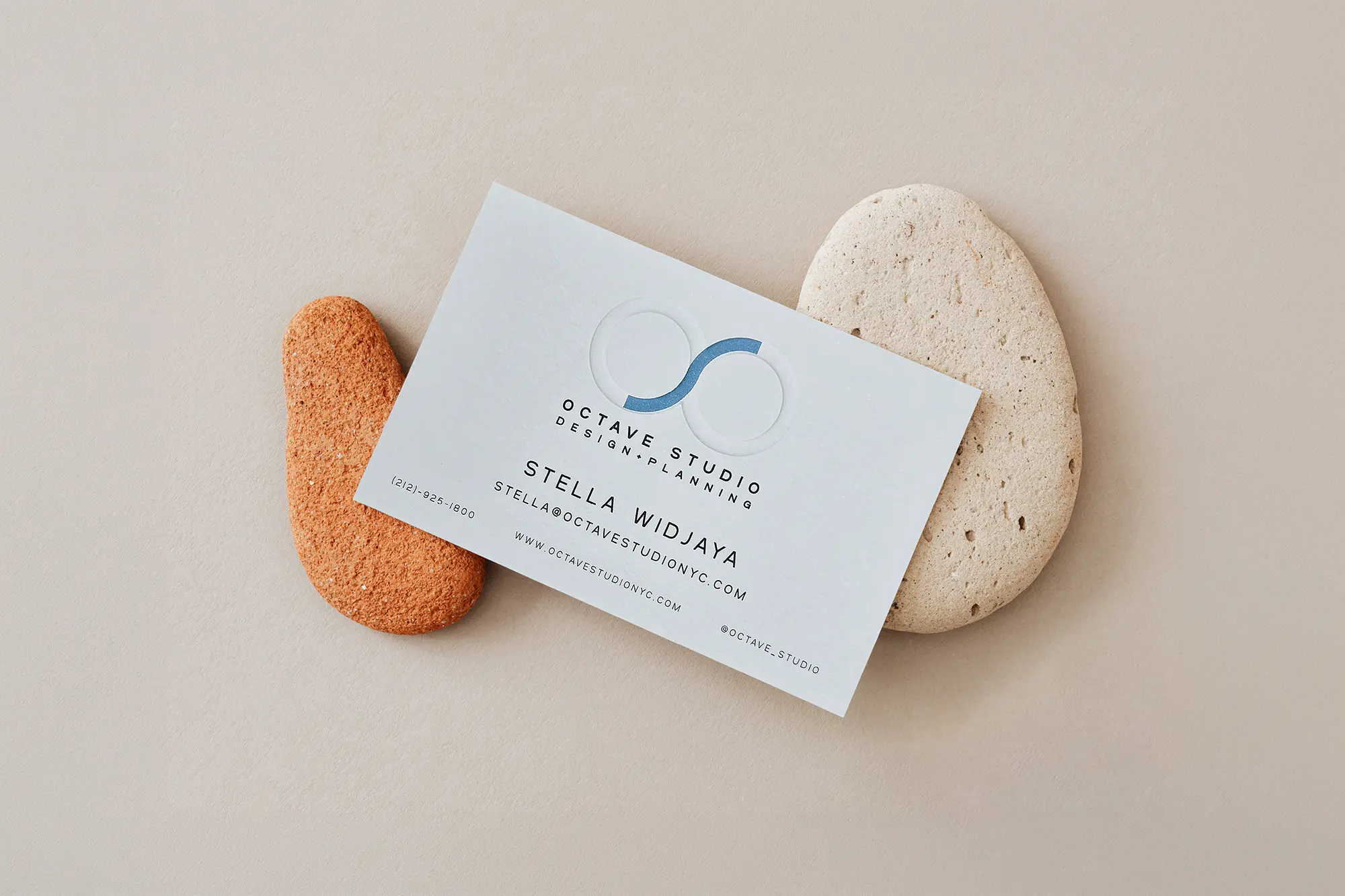 Professional business cards for Octave Studio with high-relief embossing, styled on natural river stones to highlight the tactile quality available at our Manhattan studio.