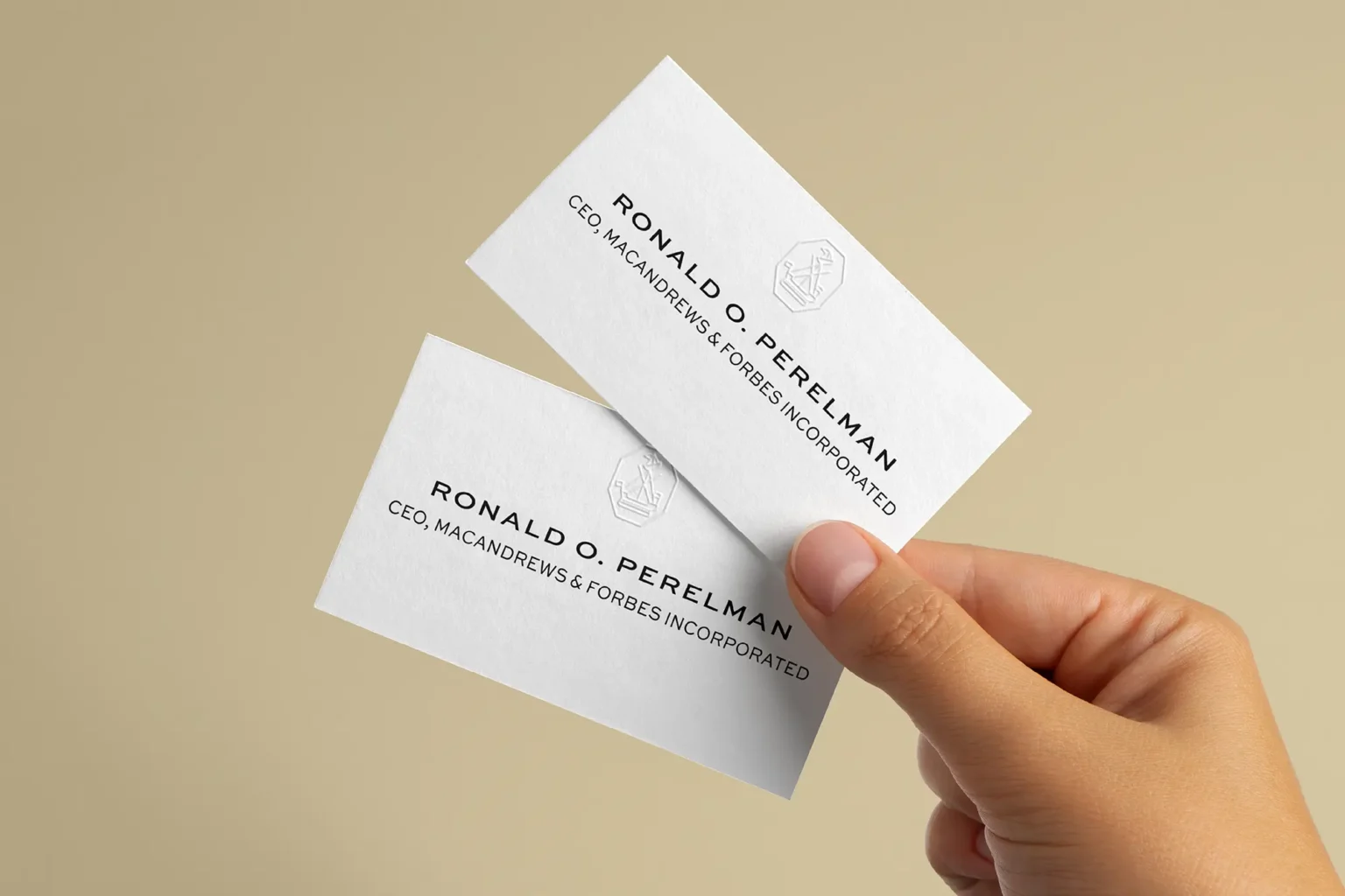 A hand holding a crisp white business card for Ronald O. Perelman, demonstrating the sharp detail and premium texture of our custom embossing process.