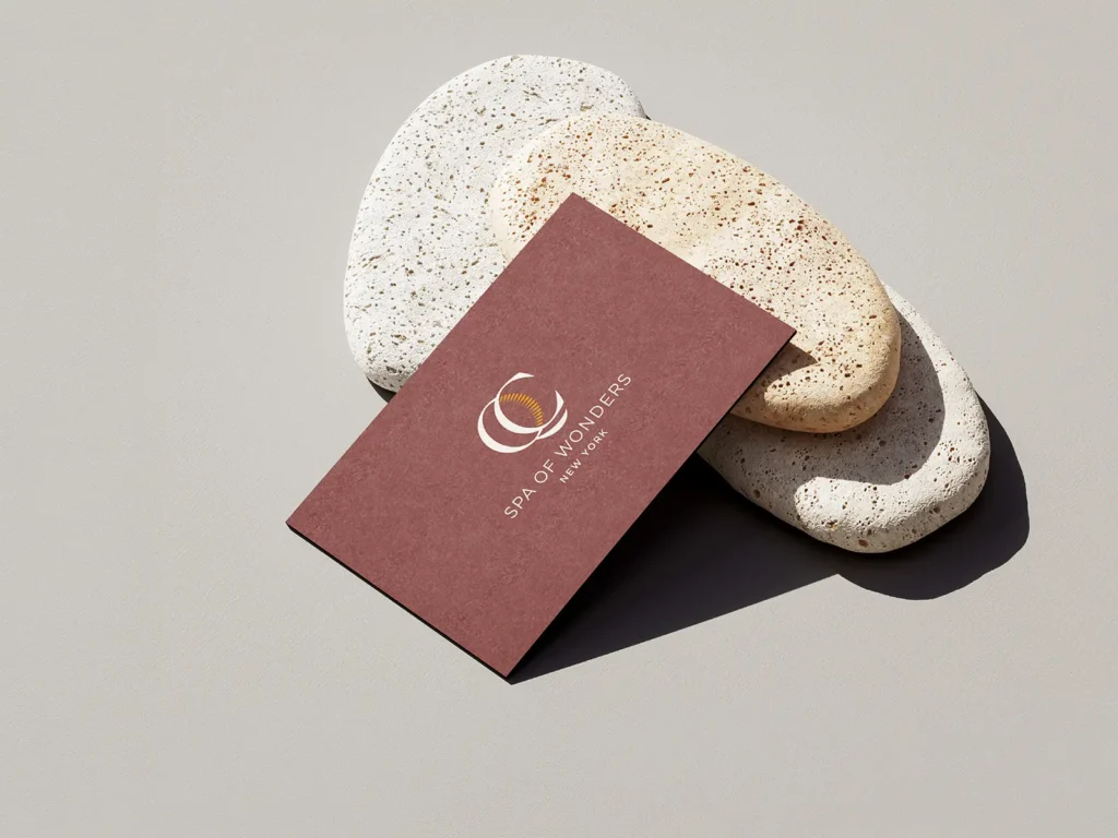 Luxury spa business card printed on 600 GSM premium cardstock, styled on smooth river stones in our NYC print shop.