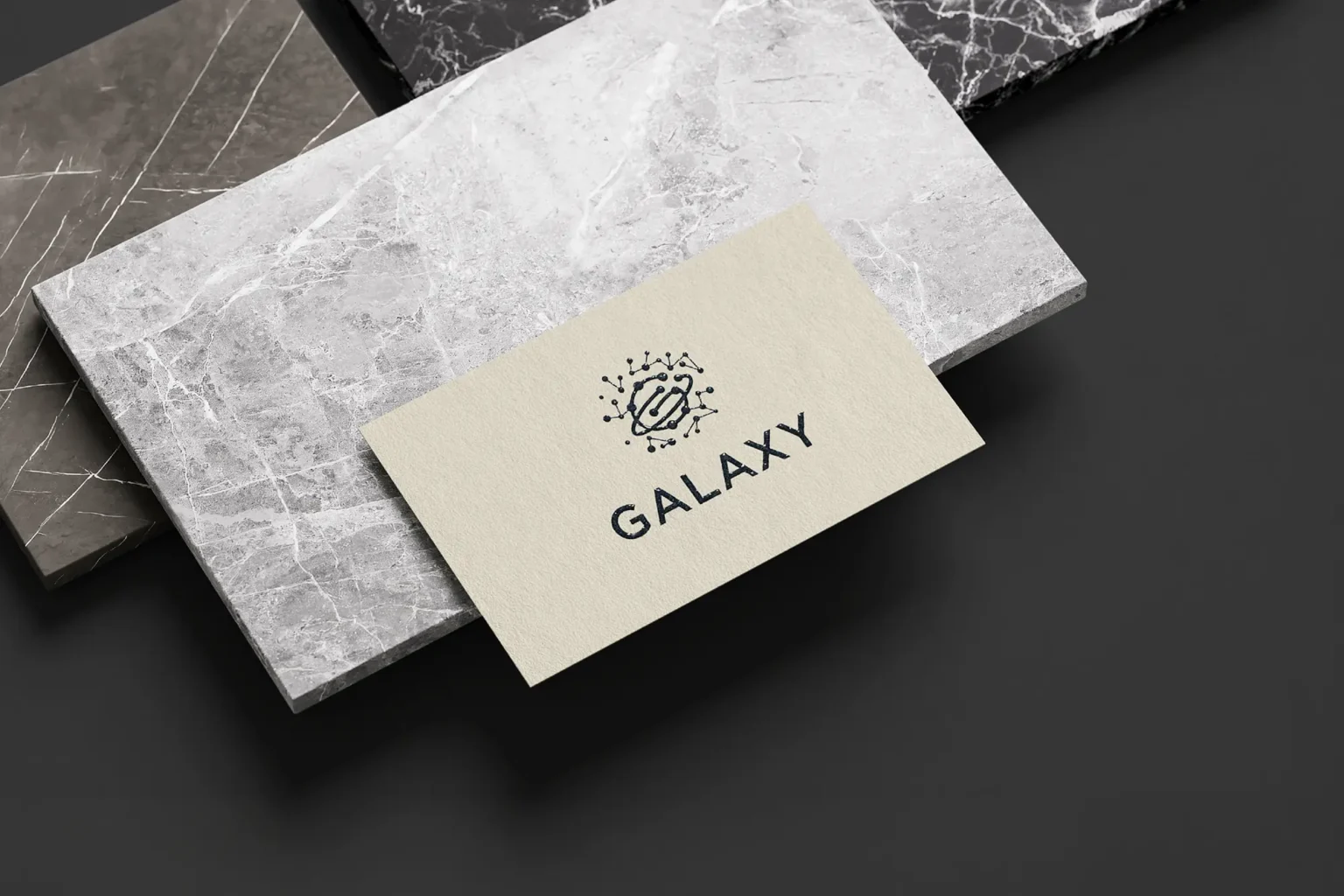Elegant Galaxy business cards on cream-colored stock with crisp thermography printing, styled on marble slabs at our Manhattan-based production facility.