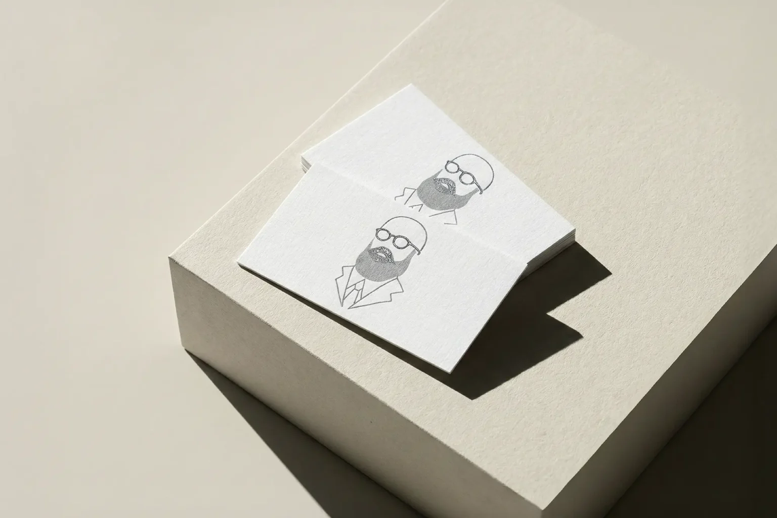 Minimalist business cards featuring a custom line-art illustration printed with tactile raised ink, stacked on clean geometric blocks to showcase the premium texture.