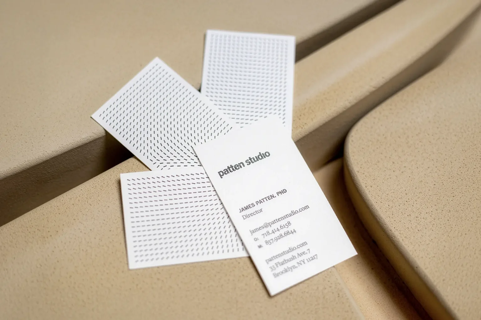 A fan of modern vertical business cards for Patten Studio showing off sharp raised ink patterns, printed locally for our Brooklyn clients on high-quality paper.