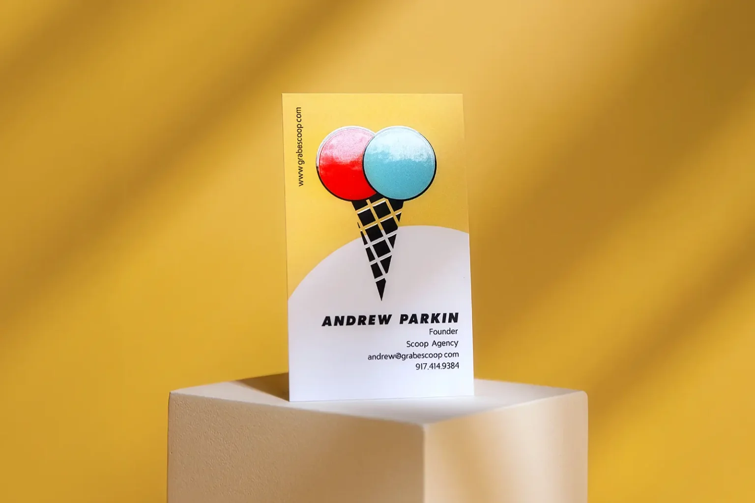 Eye-catching yellow business card for Scoop Agency with a raised gloss ice cream cone detail, custom-printed locally in Manhattan.