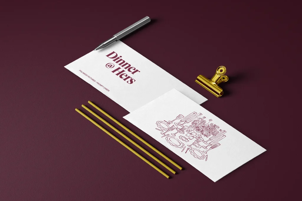 Custom-printed white envelopes for "Dinner @ Hers" featuring elegant maroon typography and line art, styled on a dark background with gold office accessories to showcase our high-quality detail.