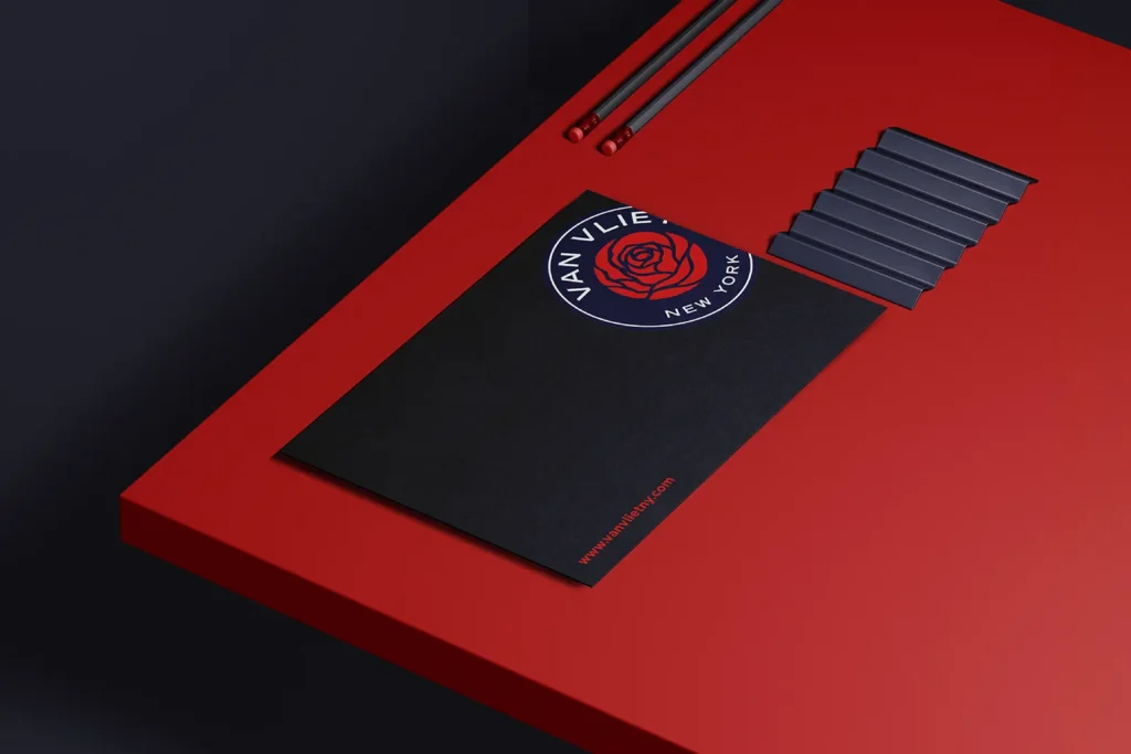 Custom "Van Vliet New York" boutique postcards featuring a bold red rose logo on black stock, professionally printed in NYC and styled with minimalist office accessories.