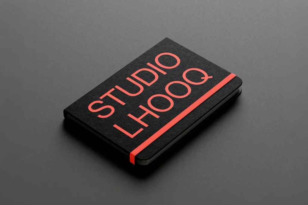 Luxury tactile branding featuring a custom black 350 GSM notebook, designed and produced in our studio to create a high-end physical brand touchpoint.