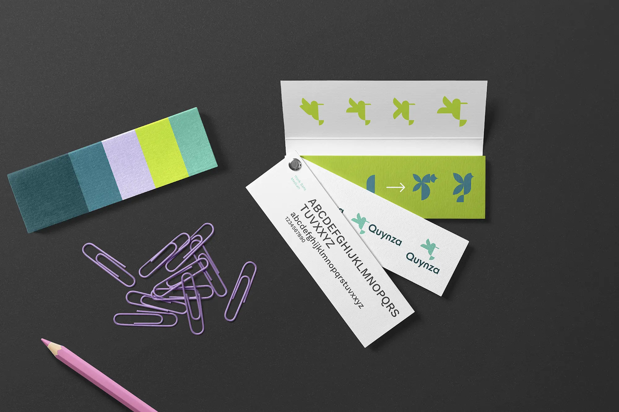 Brand guide for Quynza, locally printed in NYC for Brooklyn businesses shown with purple paper clips on a charcoal background.