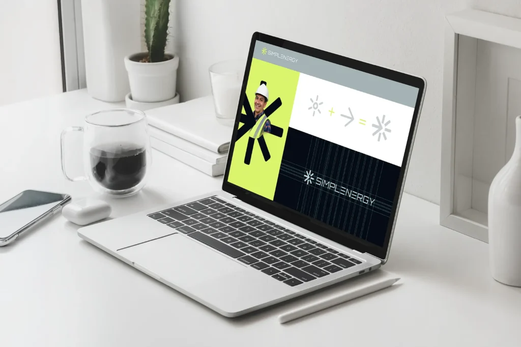 A responsive digital branding system being refined in our NYC studio, showing logo variations on a laptop to ensure a consistent visual identity across screen and print.