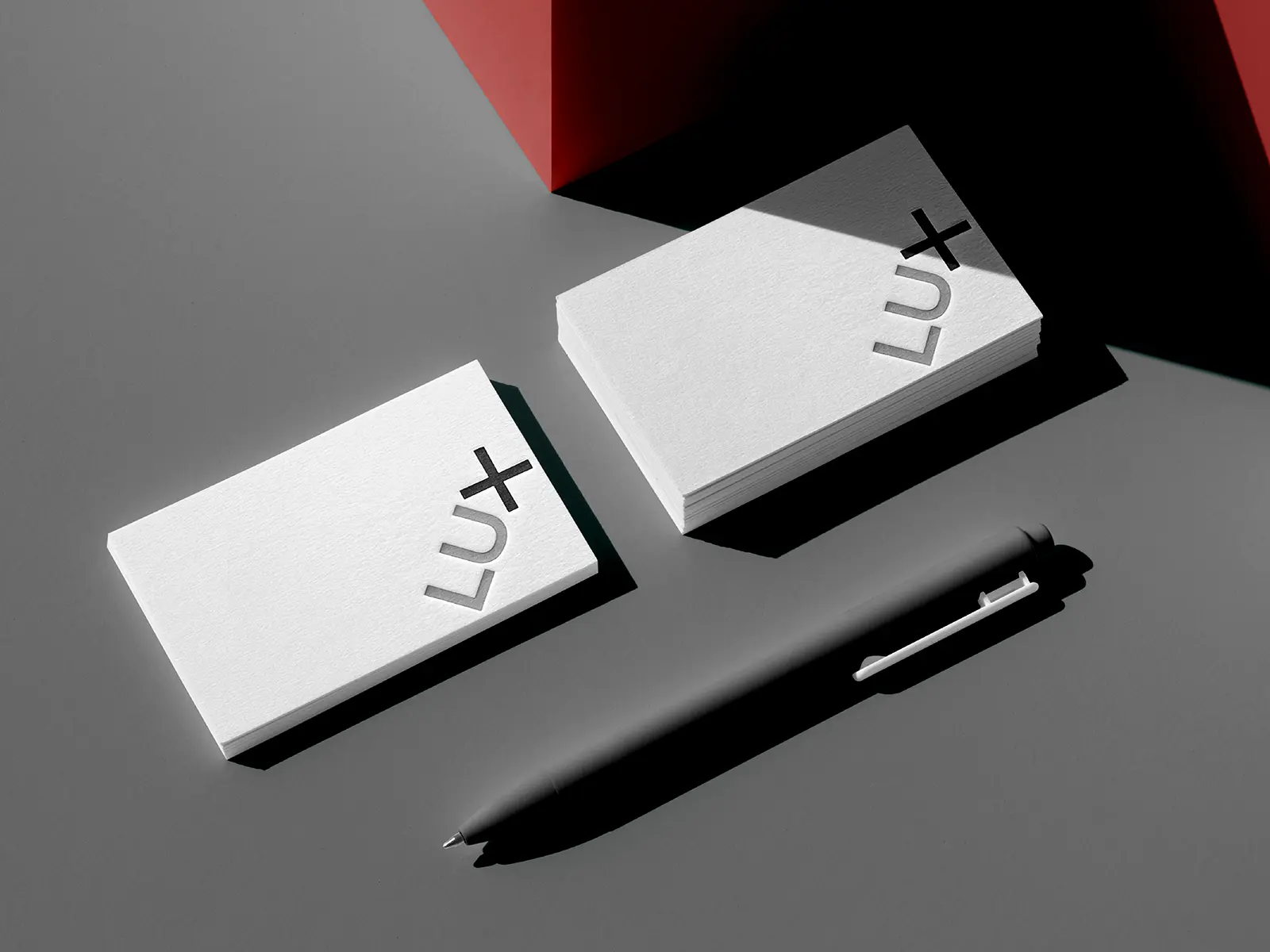 Bespoke business cards featuring a minimalist "LUX" brand identity on ultra-thick 32pt cotton paper, engineered for complex projects at our NYC shop and styled with a sleek black pen.