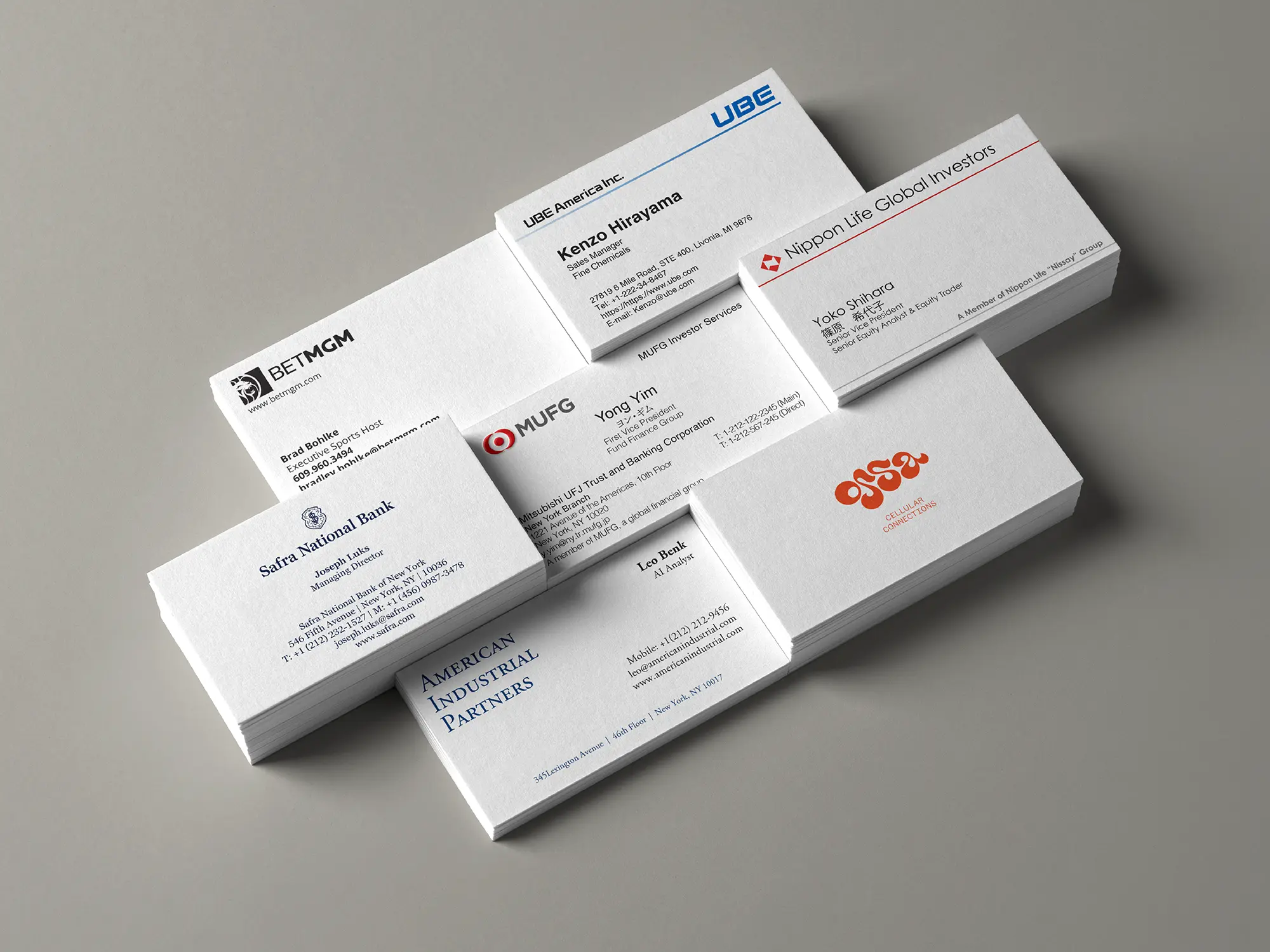 A showcase of custom business cards produced at our NYC print shop for leading financial and global institutions, featuring precision typography on premium white cardstock.